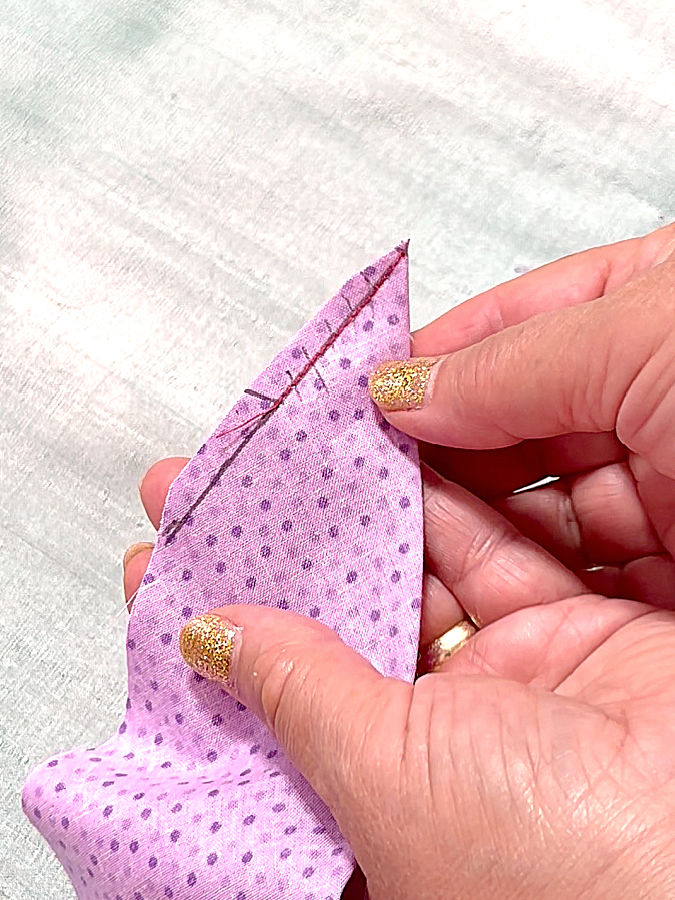 a woman holding the piece of fabric after the cut