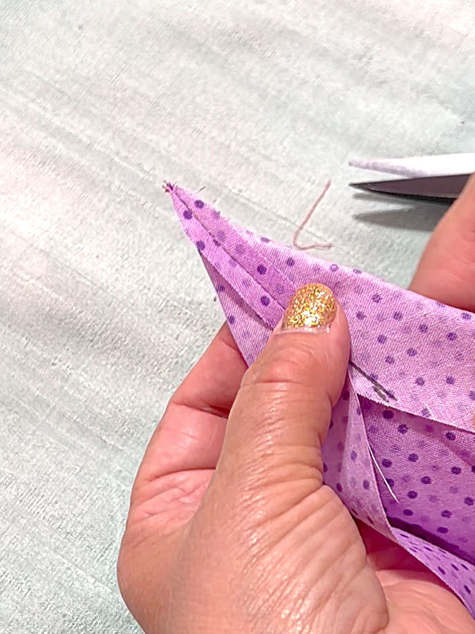 a woman holding the piece of fabric after the seam allowance was finger pressed open