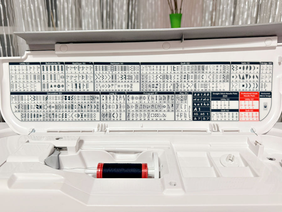 a ;ist of stitches and other capabilities of a modern sewing machine attached on the back of the top cover of the machine