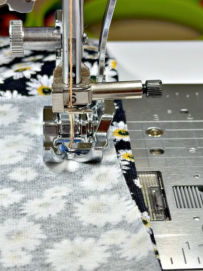 the knit presser foot while sewing a stitch on medium weight cotton jersey