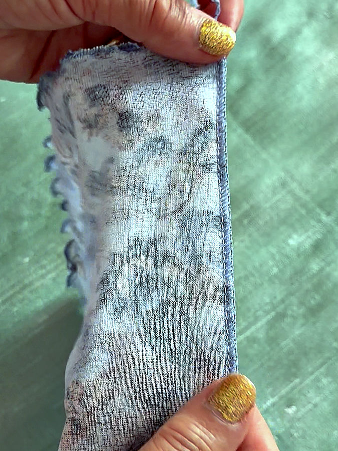 a woman holds for inspection the serged seam