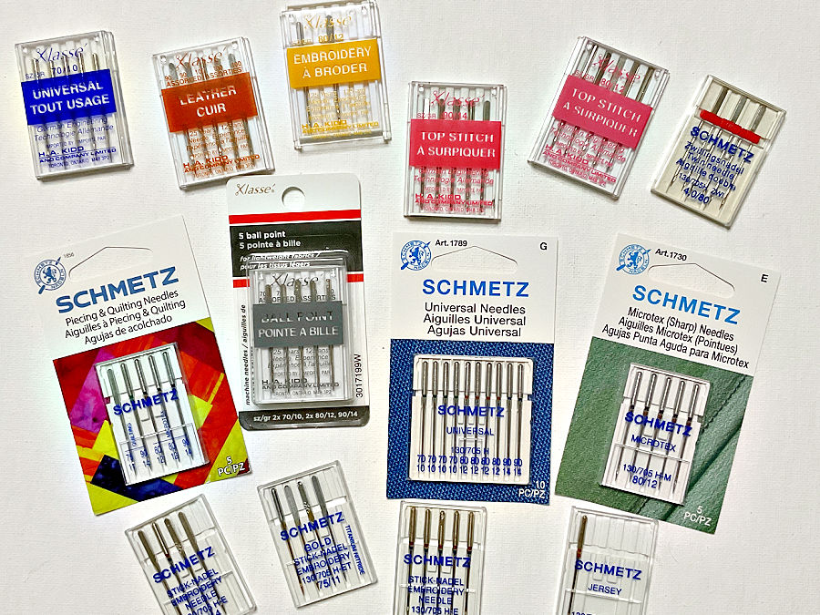 a collection of sewing machine needles of variouys typoes all in their original package
