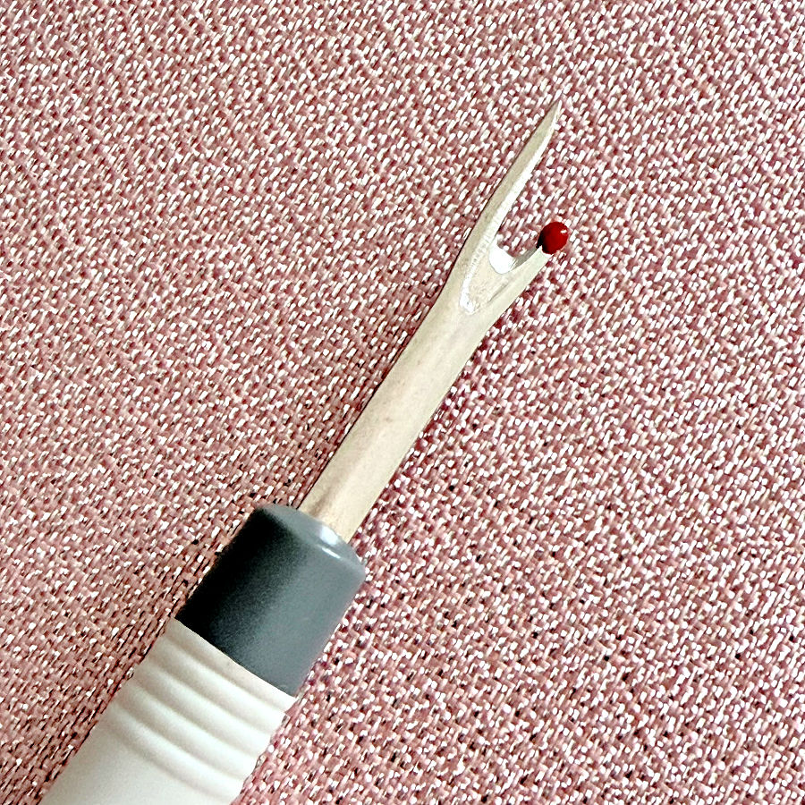 close up image of a seam ripper which has a red ball on one of the tips