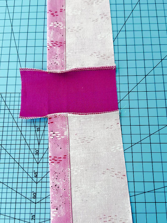 a piece of solid color material sewn between the pieces of material that are already hemmed