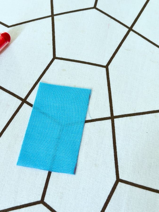 the fabric rectangle for the zipper tab lies on a table
