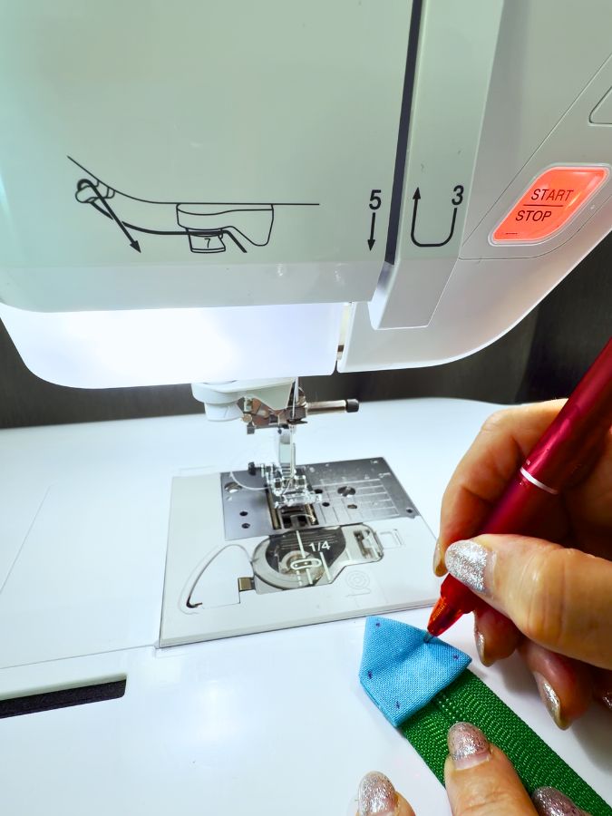 a woman uses the frixion pen to mark points on the zipper tab