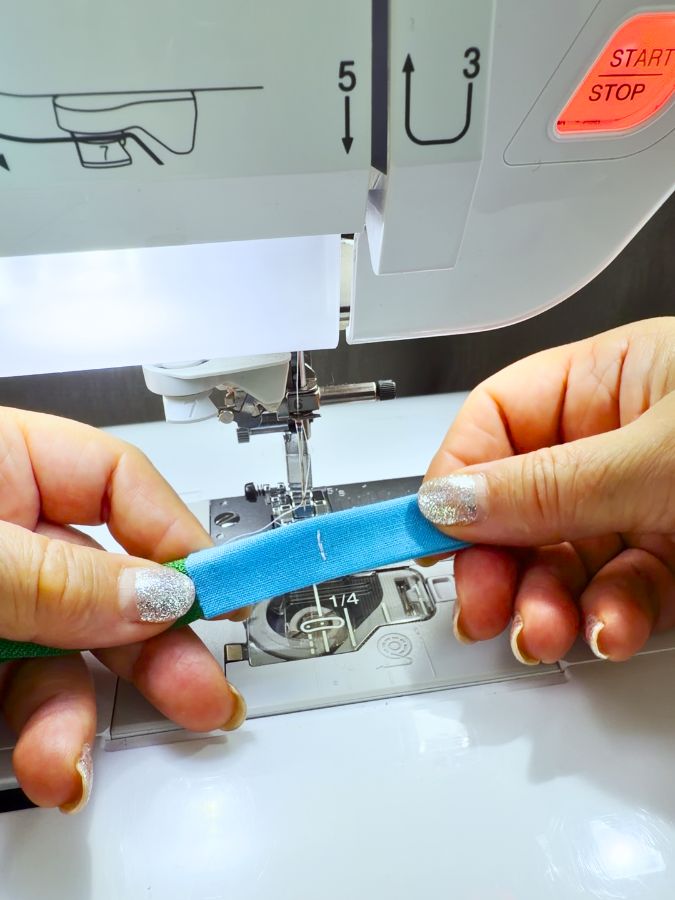 a woman holds the fabric rectangle with the stitch that gives the length of the tab