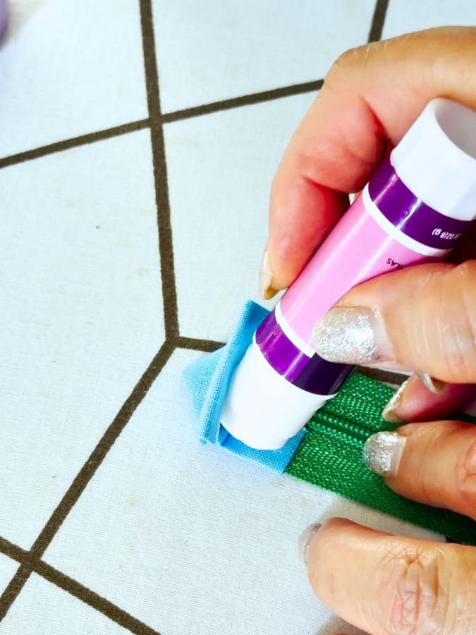 a woman is applying temporary glue to the fabric