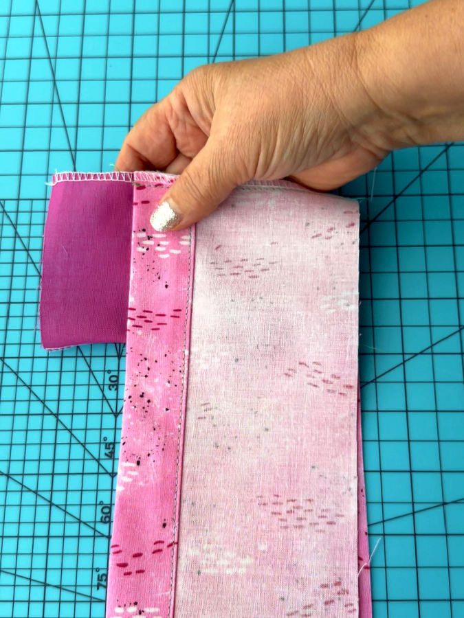 a woman holds together the iunsert and one pf the finished pieces the margins are aligned