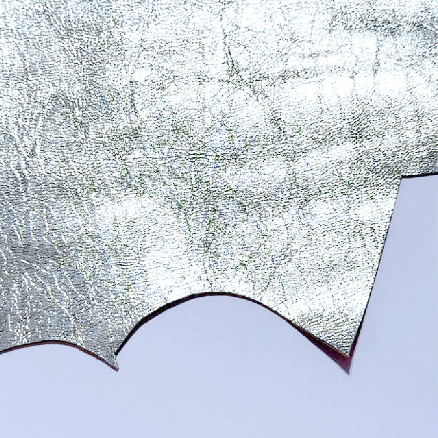 a piece of silvery thin leather from which parts have been already cut