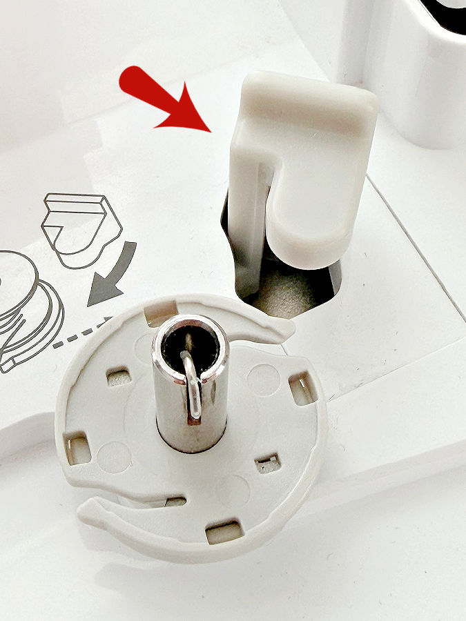 the bobbin winder of a sewing machine an arrow points to the bobbin winder stopper