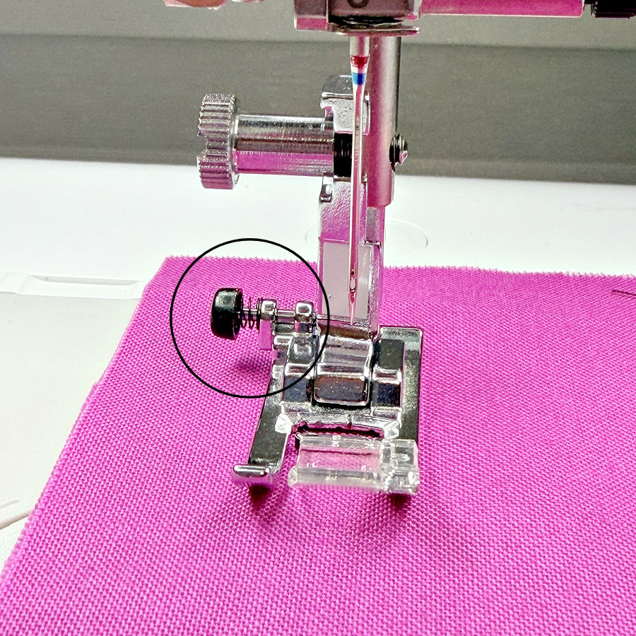 the presser foot installed in a sewing machine an arrow points to the foot leveling button
