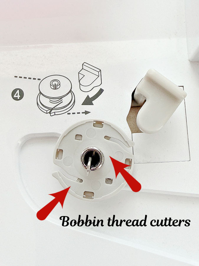 the bobbin winder on a sewing machine two arrows point to the thread cutters available on the winder