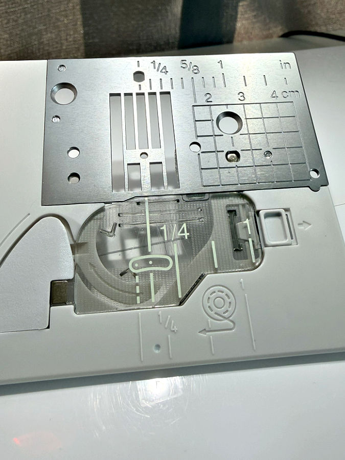 the needle plate of a sewing machine with many visible markings and signs