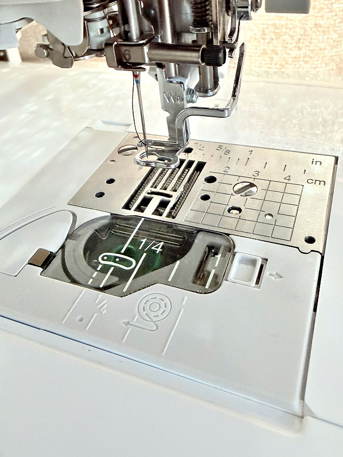 close up image of the needle plate of a sewing machine a number of holes are visible on it