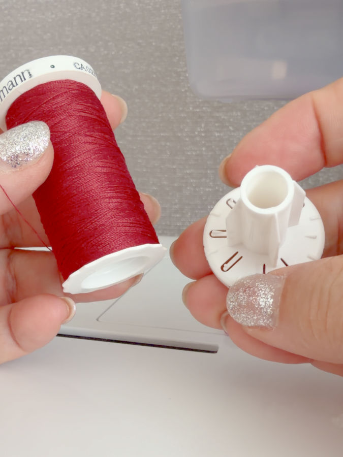 a woman holds a gutermann spool which has two separate parts