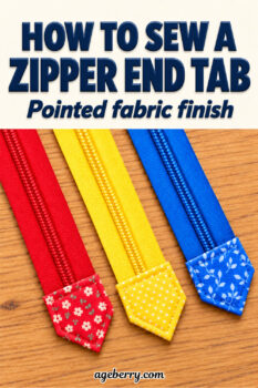 Three red, yellow, and blue zippers arranged diagonally on a wooden table, each finished with a coordinating pointed fabric end tab.